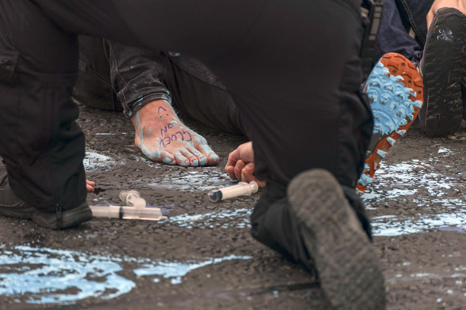 Police officers work to free protesters who had glued themselves to a slip road at Junction 4 of the A1(M), near Hatfield, where climate activists carried out a further action after demonstrations which took place last week across junctions in Kent, Essex, Hertfordshire and Surrey. Picture date: Monday September 20, 2021.