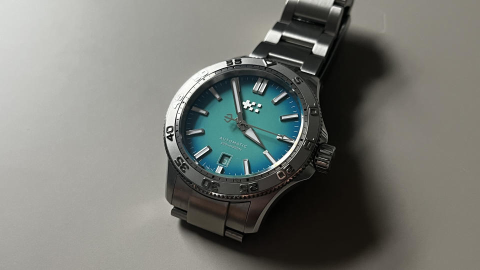 The Christopher Ward C60 Atoll 300 with a blue dial on a grey background