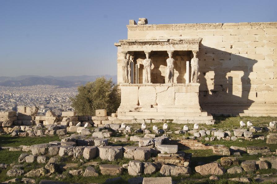 In this Dec. 11, 2016 photo, the Erechtheionin, an ancient Greek temple on the north side of the Acropolis of Athens, is seen against a backdrop of Athens. For travelers with more than beaches on their minds, there's plenty of upside to a brief winter visit to Athens that avoids the crowds and heat of summer. (Jerrin Heller via AP)