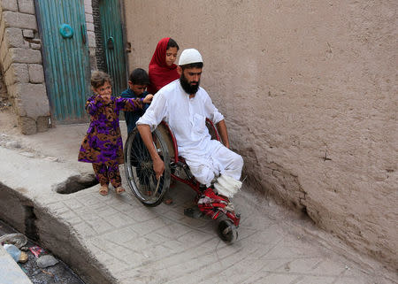 Mehrullah Safi 28, disable Afghan National Army (ANA) soldier leave with his children from their house in Jalalabad province, Afghanistan. August 2, 2017. REUTERS/Parwiz