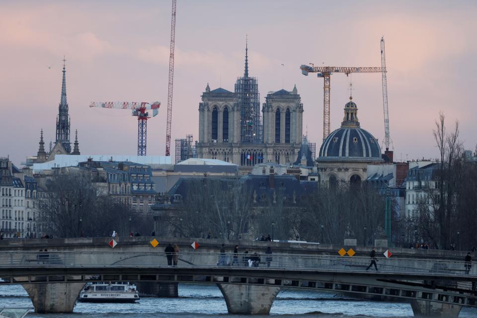 This photograph taken on February 12, 2024, shows illuminated construction site of Notre-Dame de Paris Cathedral with its rear spire, in Paris.