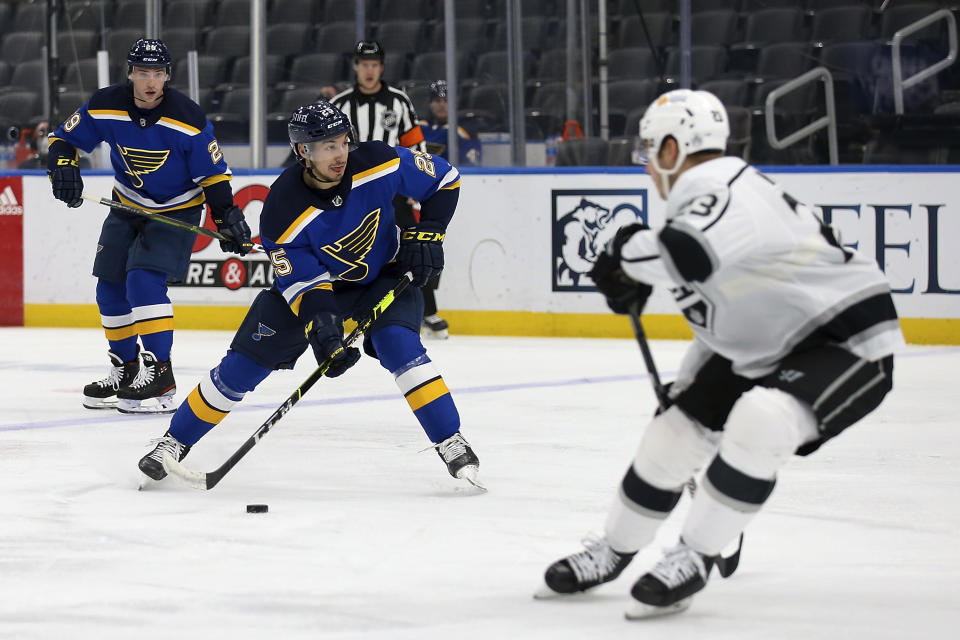 St. Louis Blues' Jordan Kyrou (25) handles the puck while Los Angeles Kings' Tobias Bjornfot (33) defends during the second period of an NHL hockey game Wednesday, Feb. 24, 2021, in St. Louis. (AP Photo/Scott Kane)