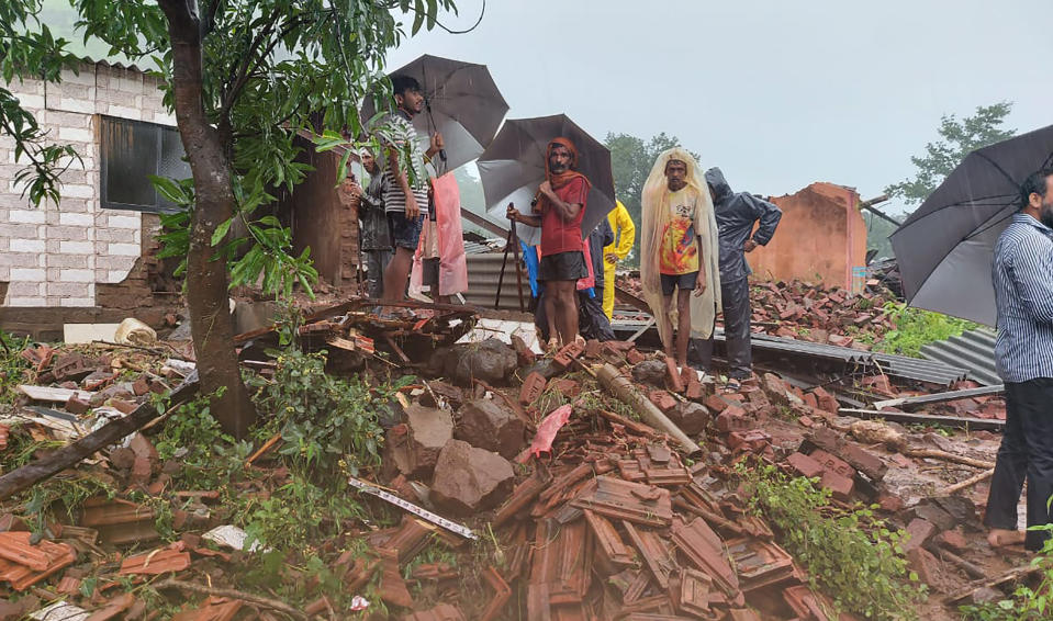 People watch rescue efforts after a landslide in Taliye village, in the western Indian state of Maharashtra, Friday, July 23, 2021. Landslides triggered by heavy monsoon rains hit parts of western India, killing at least 32 people and leading to the overnight rescue of more than 1,000 other people trapped by floodwaters, officials said Friday. (AP Photo)