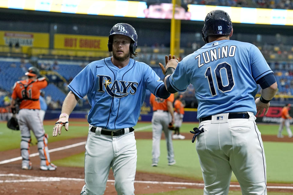 Tampa Bay Rays' Brett Phillips and Mike Zunino (10) celebrate after scoring on a two-run double by Brandon Lowe off Baltimore Orioles pitcher Jorge Lopez during the fourth inning of a baseball game Saturday, June 12, 2021, in St. Petersburg, Fla. (AP Photo/Chris O'Meara)