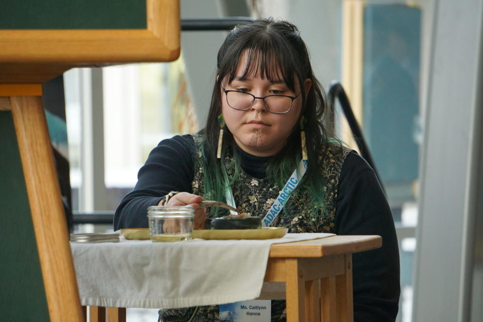 University of Alaska Fairbanks Caitlynn Hanna, who is from the Kotzebue, lights a traditional Inupiat seal-oil lamp at the start of the April 9 ceremony at the University of Alaska Anchorage marking the opening of the ADAC-ARCTIC research center there. Hanna is pursuing a masters degree in civil engineering and worked previously as a fellow with the earlier Arctic Domain Awareness Center that operated at UAA. (Photo by Yereth Rosen/Alaska Beacon)