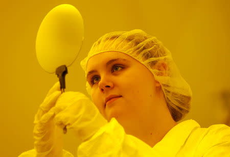 An employee checks a semiconductor wafer in a yellow light clean room at the new BOSCH research and advance development centre Campus Renningen during a guided media tour in Renningen, Germany in this September 30, 2015 file photo. REUTERS/Ralph Orlowski/Files