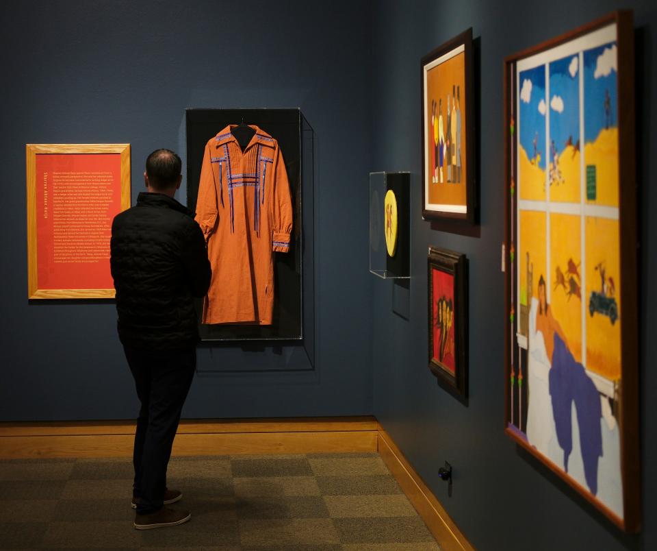 A man stops to look on Feb. 16 at a cotton "Ribbon Dress" by Kiowa artist Sharron Ahtone Harjo, which is on view in the National Cowboy & Western Heritage Museum's new exhibition "Lighting Pathways: Matriarchs of Oklahoma Native Art."