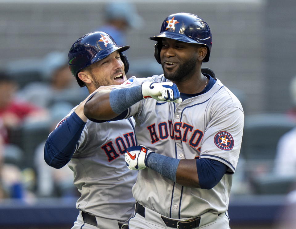 Houston Astros designated hitter Yordan Alvarez, right, is congratulated by teammate Alex Bregman, left, after they scored on his two-run home run against the Toronto Blue Jaysi n ninth-inning baseball game action in Toronto, Monday, July 1, 2024. (Frank Gunn/The Canadian Press via AP)