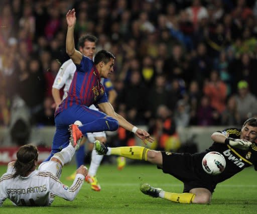 Barcelona's forward Alexis Sanchez (up) scores despite Real Madrid's defender Sergio Ramos (L) and goalkeeper Iker Casillas (R) during the Spanish League "El Clasico" football match at the Camp Nou stadium in Barcelona. Real Madrid won 2-1