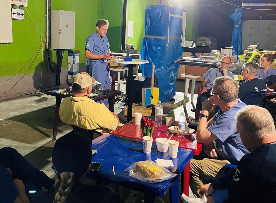 Chris Brandenburg (standing) speaking to other members of humanitarian aid organization Samaritan's Purse in the underground emergency field hospital in Lviv, Ukraine.