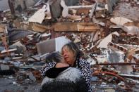 A woman reacts while embracing another person, near rubble following an earthquake in Hatay, Turkey (REUTERS)