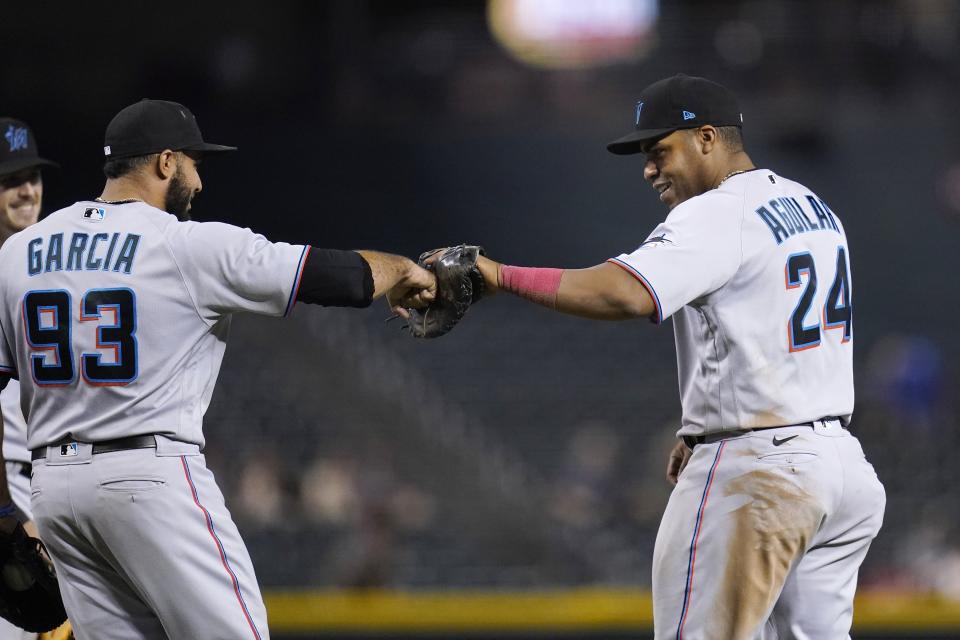 Miami Marlins first baseman Jesus Aguilar (24) celebrates with relief pitcher Yimi Garcia (93) after the team's baseball game against the Arizona Diamondbacks on Wednesday, May 12, 2021, in Phoenix. The Marlins won 3-2. (AP Photo/Ross D. Franklin)