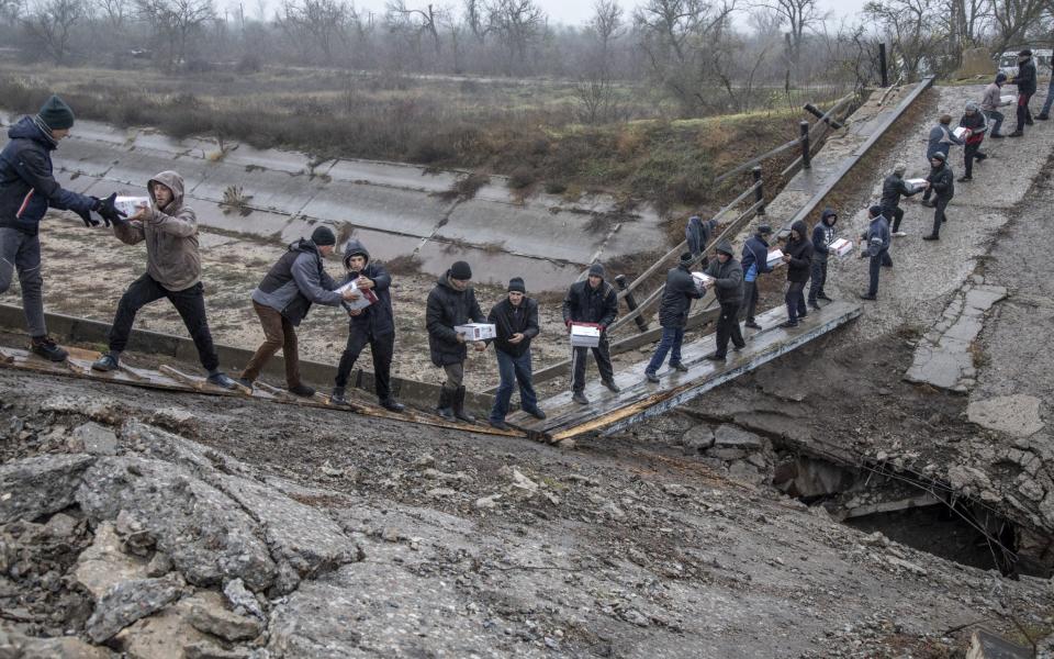 Locals form a human chain over the wreckage of a bridge - Narciso Contreras/Anadolu Agency 