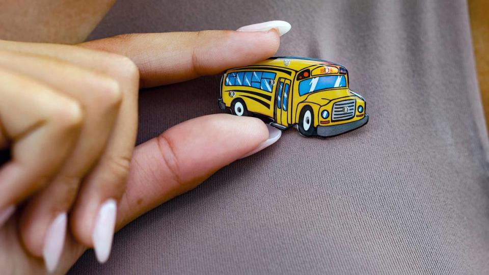 La estudiante de MAST Academy Lilly Thorpe, de 14 años, usando un pin para celebrar que las Escuelas Públicas del Condado Miami-Dade (MDCPS) presentaron 20 nuevos autobuses eléctricos como parte de su flota de casi 1,000 vehículos en Miami el martes 15 de agosto de 2023.