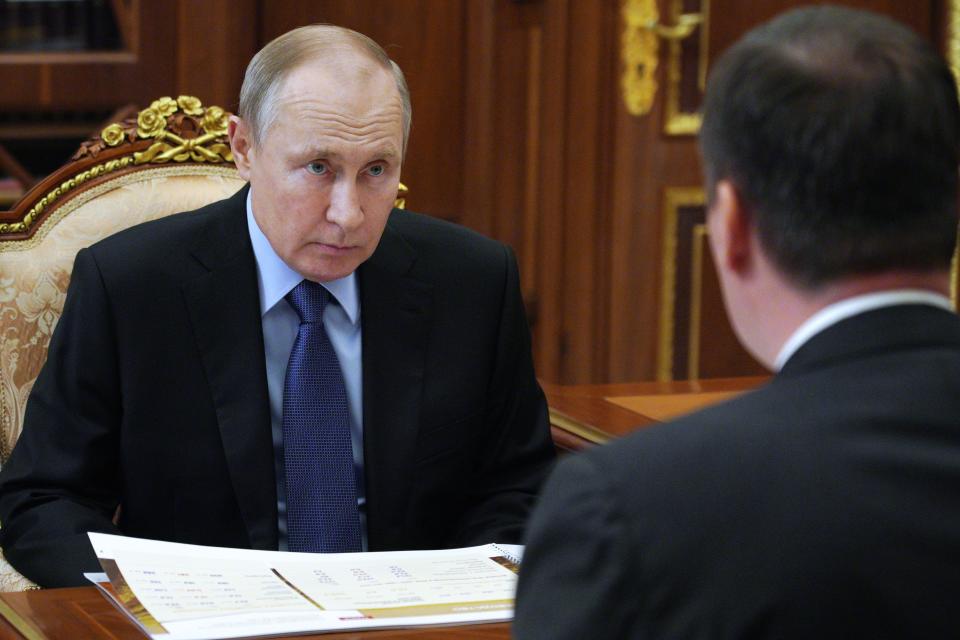 Russian President Vladimir Putin listens to Russian Agriculture Minister Dmitry Patrushev, back to a camera, during their meeting at the Kremlin in Moscow, Russia, Monday, April 5, 2021. (Alexei Druzhinin, Sputnik, Kremlin Pool Photo via AP)