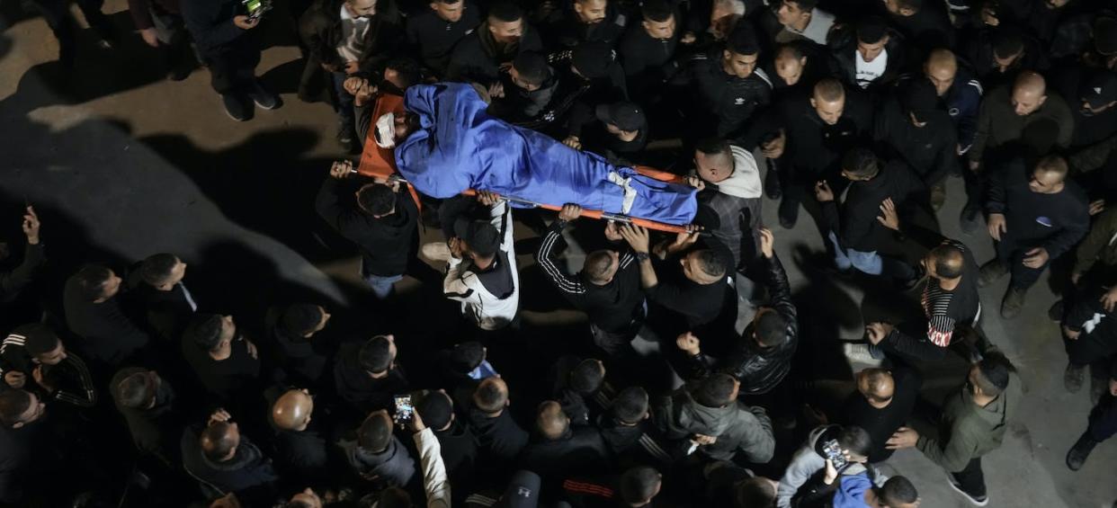 Palestinians carry the body of a man who was killed during an Israeli military raid in the West Bank city of Jenin in March 2023. (AP Photo/Majdi Mohammed)