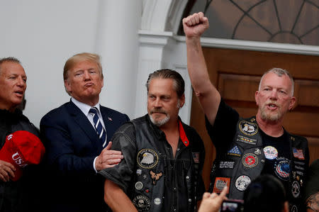 U.S. President Donald Trump meets with supporters from a group called "Bikers for Trump" at the Trump National Golf Club in Bedminster, New Jersey, U.S., August 11, 2018. Reuters photographer Carlos Barria: "President Trump likes to be celebrated by supporters, and none better than a group known as "Bikers for Trump," who visited him at Trump National Golf Club in Bedminster, New Jersey, this summer. Unfortunately, it poured down that day and plans for an outdoor event gave way to a short visit inside the clubhouse for a group photo." REUTERS/Carlos Barria