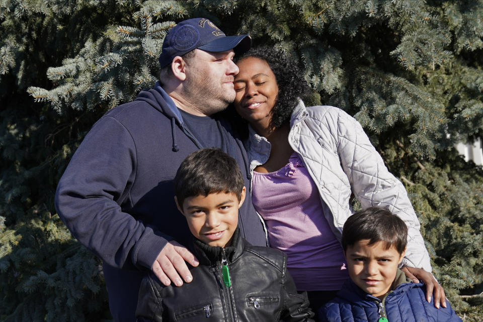 Aaron Crawford, his wife Sheyla and their sons, Sornic, left, and Gabriel, stand for a photograph outside their Apple Valley, Minn., home on Saturday, Nov. 21, 2020. The couple turned to a Minnesota nonprofit, 360 Communities, part of Feeding America's food bank network, when the pandemic's economic fallout put them in peril. The couple and their two young sons are among the millions who've flocked to food banks as hunger has reached record levels since the virus took hold in America. The Crawfords are now getting aid from federal food stamps. (AP Photo/Jim Mone)