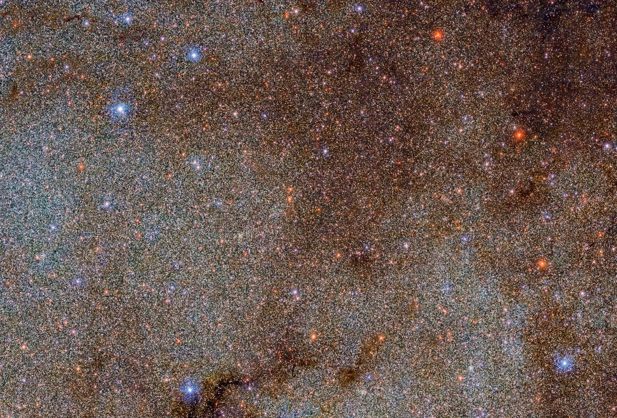 This image, which is brimming with stars and dark dust clouds, is a small extract — a mere pinprick — of the full Dark Energy Camera Plane Survey (DECaPS2) of the Milky Way (DECaPS2/DOE/FNAL/DECam/CTIO/NOIRLab/NSF/AURA Image processing: M. Zamani & D. de Martin (NSFâ€™s NOIRLab))