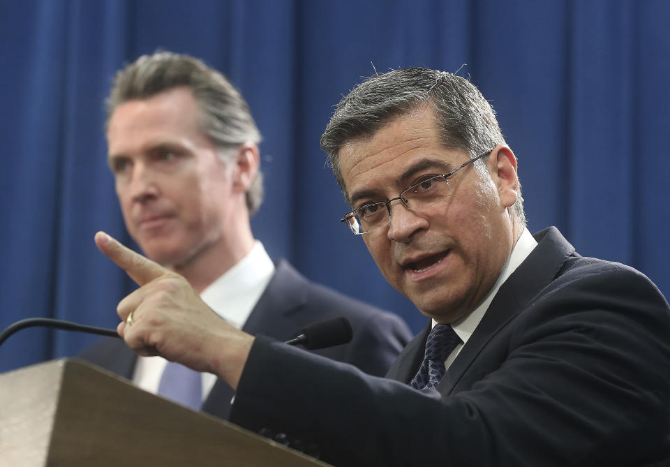 FILE - In this Feb. 15, 2019, file photo, California Attorney General Xavier Becerra, right, accompanied by Gov. Gavin Newsom, said California was probably suing President Donald Trump over his emergency declaration to fund a wall on the U.S.-Mexico border in Sacramento, Calif. Becerra filed a lawsuit Monday, Feb. 18, against Trump's emergency declaration to fund a wall on the U.S.-Mexico border. Becerra released a statement Monday, saying 16 states — including California — allege the Trump administration's action violates the Constitution. (AP Photo/Rich Pedroncelli, File)