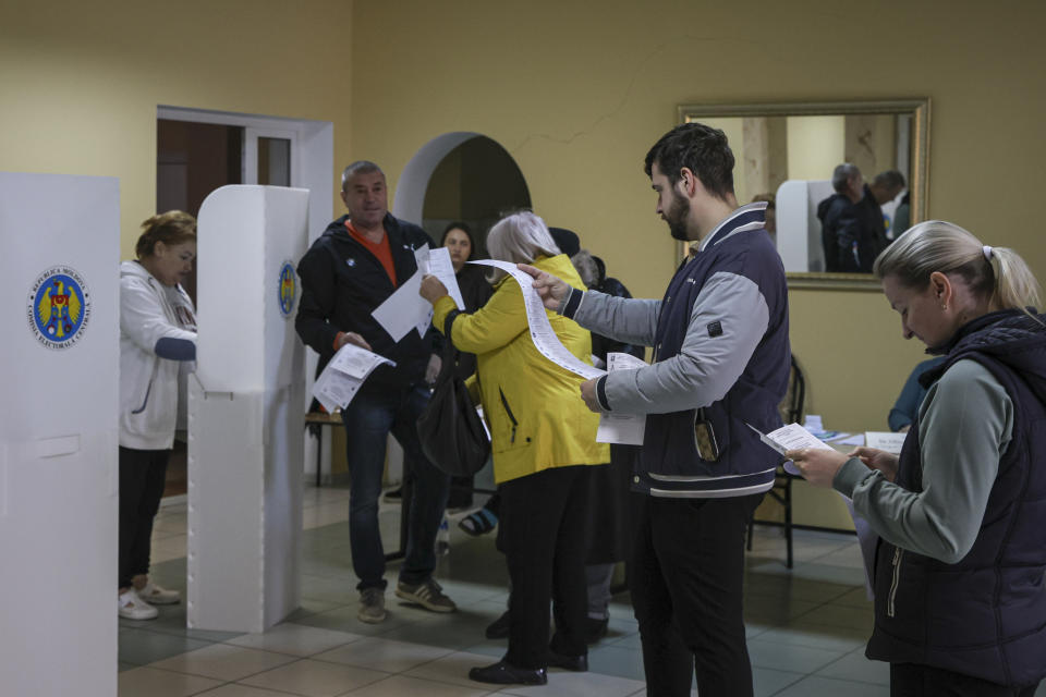 Moldovans look at candidates lists on the ballot during local elections in Chisinau, Moldova, Sunday, Nov. 5, 2023. Moldovans will cast ballots in nationwide local elections on Sunday amid claims by Moldovan authorities that Russia has been conducting a "hybrid warfare" to undermine the vote in the European Union candidate country. (AP Photo/Aurel Obreja)