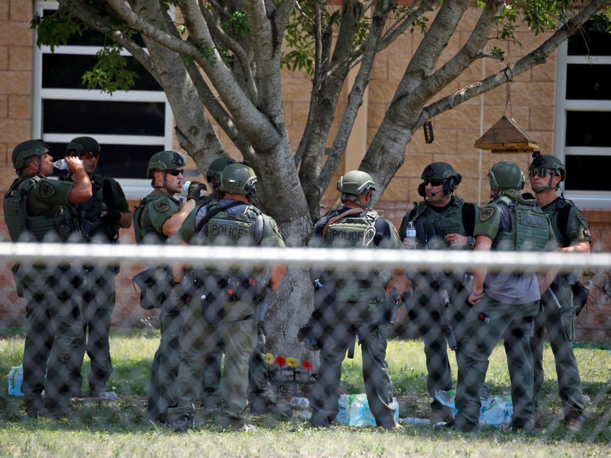 Law enforcement personnel stand outside Robb Elementary School