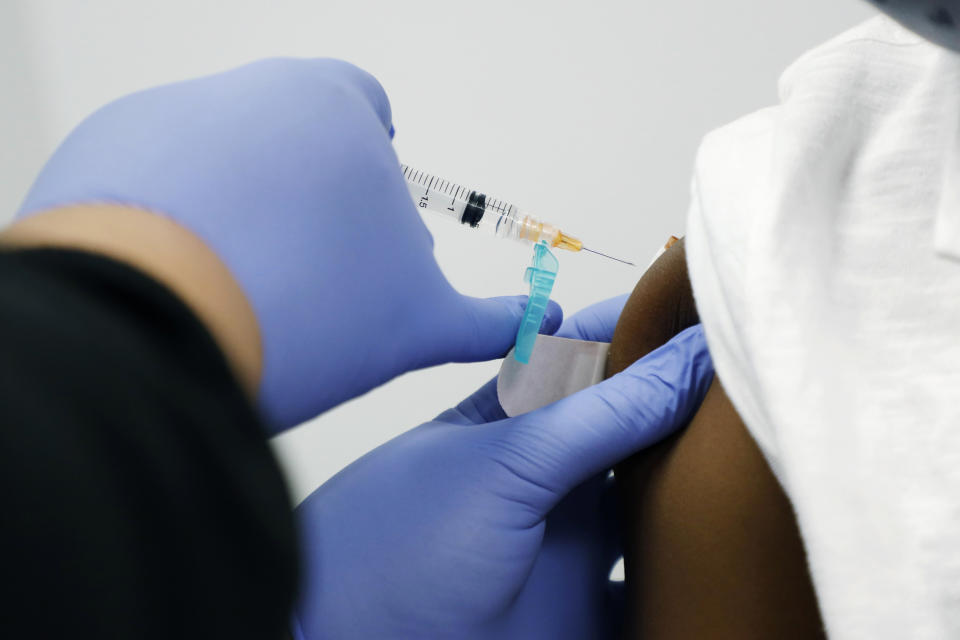 Jeremiah Young, 11, receives one of a series of vaccinations during his back-to-school physical exam with Dr. Janice Bacon, Aug. 14, 2020, while at the Community Health Care Center on the Tougaloo College campus in Tougaloo, Miss. A Black primary care physician practicing in Mississippi for nearly four decades, Bacon works at an all-African American-run trio of community health centers in Hinds County, where the population is overwhelmingly Black — and where the most coronavirus cases have been reported in the state. (AP Photo/Rogelio V. Solis)