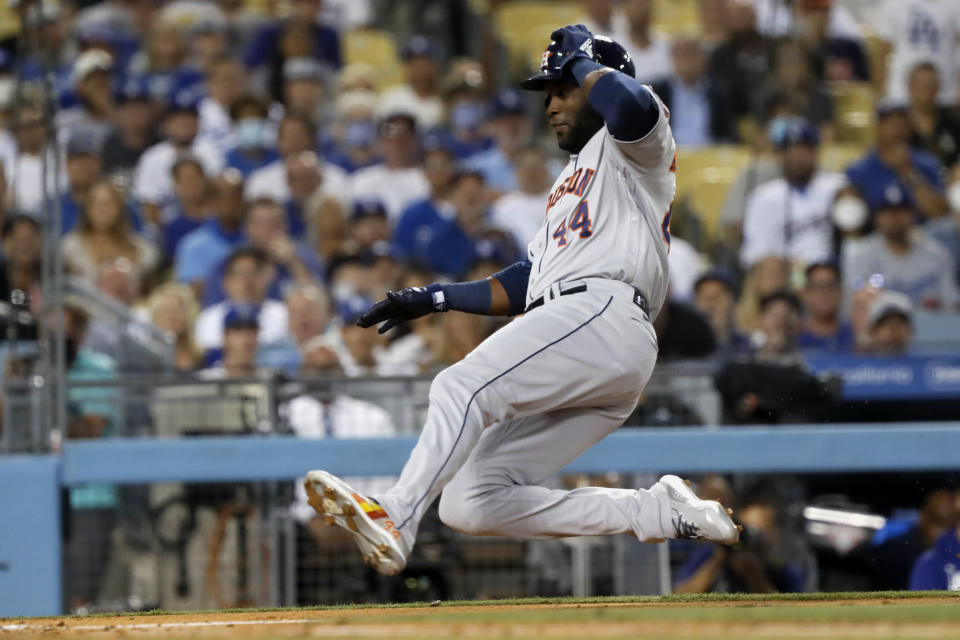 Houston Astros' Yordan Alvarez slides into home on a single by Kyle Tucker during the fourth inning of the team's baseball game against the Los Angeles Dodgers in Los Angeles, Wednesday, Aug. 4, 2021. (AP Photo/Alex Gallardo)