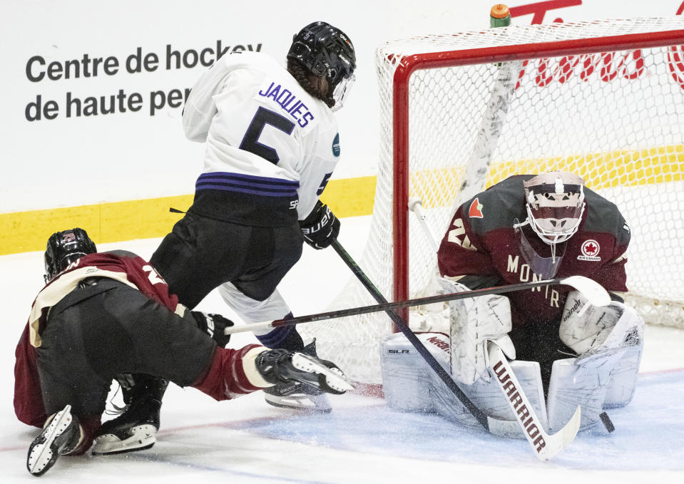Montreal goaltender Elaine Chuli (20) makes a save against Minnesota's Sofie Jaques (5) as Montreal's Marie-Philip Poulin defends during the third period of a PWHL hockey game Thursday, April 18, 2024, in Montreal. (Christinne Muschi/The Canadian Press via AP)