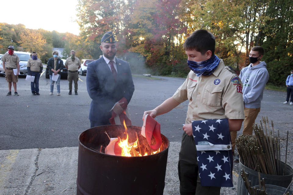 FILE - In this Tuesday, Oct. 13, 2020 file photo, Jondavid Longo, Republican mayor of Slippery Rock, Pa., center, presides over a Boy Scouts flag retirement ceremony where worn out flags are cut up and burned in Slippery Rock. Longo says the 2020 election has changed politics in his town, surfacing resentments from voters on both sides. The lingering tensions now overshadow issues once considered local — such as funding the police and libraries. (AP Photo/Ted Shaffrey)