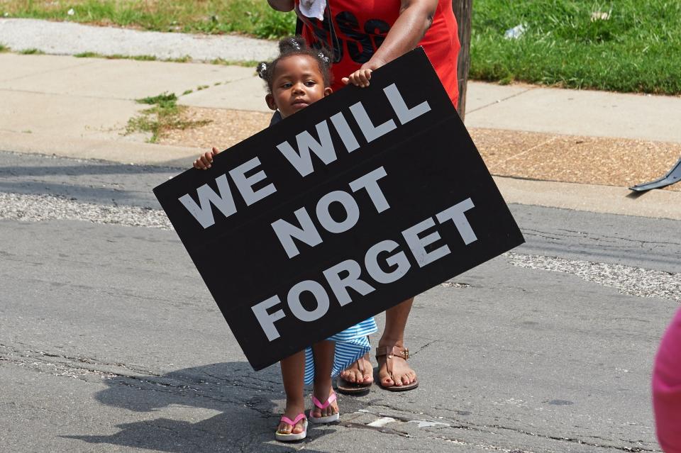 A young girl holds a sign on Aug. 8, 2015, in Ferguson, Missouri, a year after the police shooting death of Michael Brown Jr. (Photo: MICHAEL B. THOMAS/AFP via Getty Images)