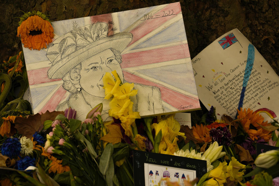A drawing and message cards are placed among floral tributes to Queen Elizabeth II, the day after her funeral in London's Green Park, Tuesday, Sept. 20, 2022. The Queen, who died aged 96 on Sept. 8, was buried at Windsor alongside her late husband, Prince Philip, who died last year. (AP Photo/Vadim Ghirda)