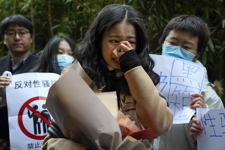 Zhou Xiaoxuan, center, weeps as she speaks to her supporters upon arrival at a courthouse in Beijing, Wednesday, Dec. 2, 2020. Zhou, a Chinese woman who filed a sexual harassment lawsuit against a TV host, told dozens of cheering supporters at a courthouse Wednesday she hopes her case will encourage other victims of gender violence in a system that gives them few options to pursue complaints. (AP Photo/Andy Wong)