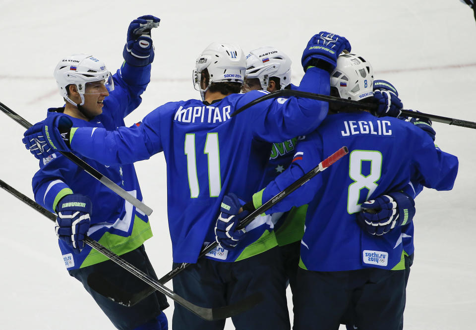 Slovenia forward Anze Kopitar (11) celebrates with teammates after scoring a goal against Austria in the first period of a men's ice hockey game at the 2014 Winter Olympics, Tuesday, Feb. 18, 2014, in Sochi, Russia. (AP Photo/Julio Cortez)