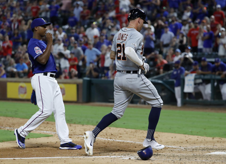 Detroit Tigers' JaCoby Jones (21) scores on a wild pitch thrown by Texas Rangers' Jose Leclerc, left, during the ninth inning of a baseball game in Arlington, Texas, Friday, Aug. 2, 2019. (AP Photo/Tony Gutierrez)