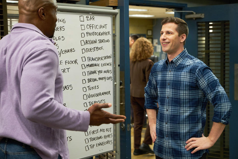 Terry Crews explaining something to Andy Samberg.