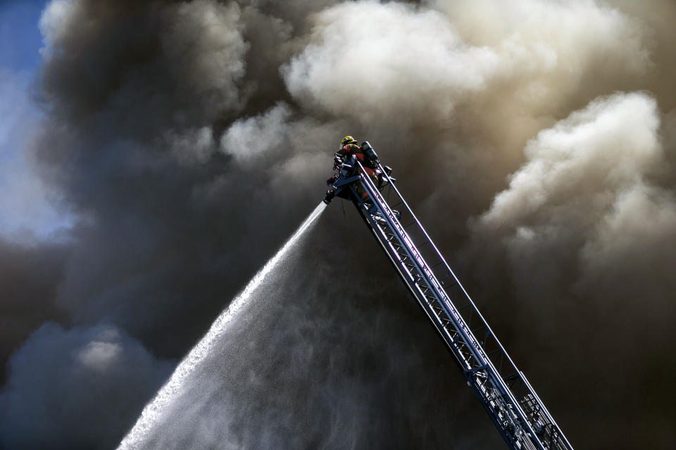 Portland Fire & Rescue work at the scene of a major apartment fire in downtown Portland, Ore., Tuesday, May 16, 2023. Firefighters rescued people and at least one dog from a dramatic, three-alarm apartment fire in downtown Portland on Tuesday before they were ordered to fall back. (Sean Meagher/The Oregonian via AP)