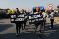 Farmers carry placards at a site of a protest against the newly passed farm bills at Singhu border near Delhi