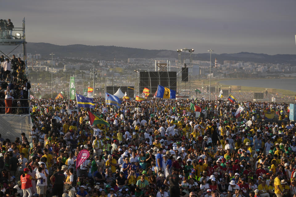 People waiting for the start of a vigil with Pope Francis, ahead of the 37th World Youth Day, flock together at the Parque Tejo in Lisbon, Saturday, Aug. 5, 2023. On Sunday morning, the last day of his five-day trip to Portugal, Francis is to preside over a final, outdoor Mass on World Youth Day – when temperatures in Lisbon are expected to top 40 degrees C (104F) – before returning to the Vatican. (AP Photo/Gregorio Borgia)