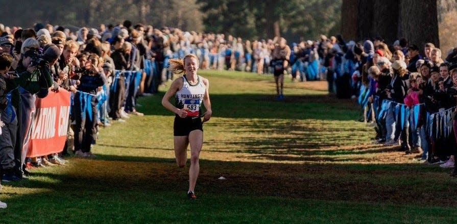 Hannah Stoffel, while at Huntington University, runs through a tunnel of spectators to win NAIA cross-country title at Vancouver, Wash., Nov. 22, 2019.