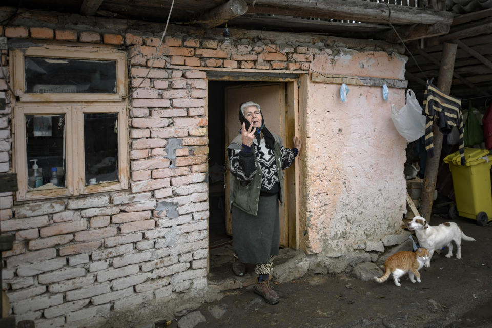 An elderly woman gestures while watching Valeriu Nicolae deliver basic goods to families with school children in Nucsoara, Romania, Saturday, Jan. 9, 2021. Valeriu Nicolae and his team visited villages at the foot of the Carpathian mountains, northwest of Bucharest, to deliver aid. The rights activist has earned praise for his tireless campaign to change for the better the lives of the Balkan country’s poorest and underprivileged residents, particularly the children. (AP Photo/Andreea Alexandru)