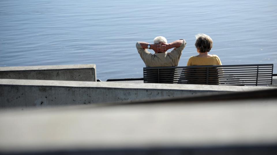 Ein Senioren-Paar auf einer Bank an der Elbe. Seit Juli 2014 können Arbeitnehmer nach mindestens 45 Jahren Einzahlung in die Rentenkasse bereits ab 63 Jahren abschlagsfrei in Rente gehen. Foto: Christian Charisius