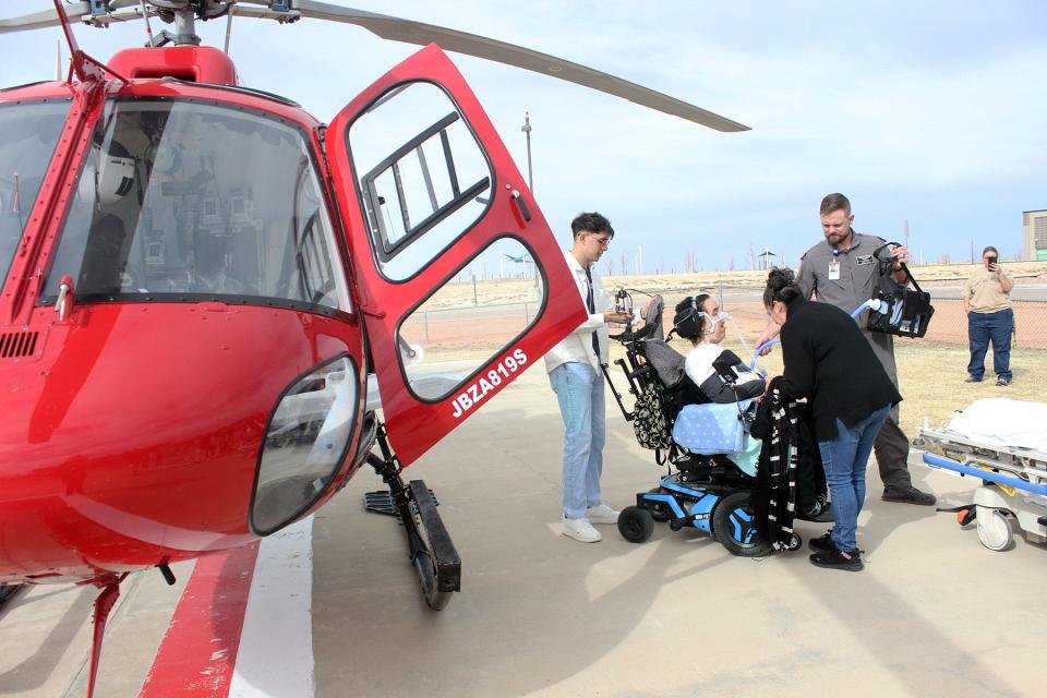 Cesar Malagon gets help preparing for the helicopter ride from his cousin Erick Daniel Avila (left) as well as his mother and a LifeLine paramedic.