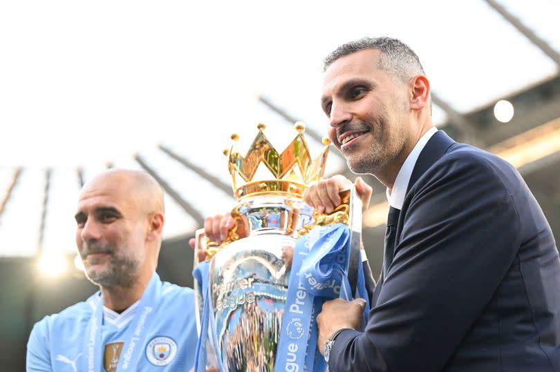 Khaldoon Al Mubarak, Chairman of Manchester City, and Pep Guardiola, Manager of Manchester City, pose for a photo with the Premier League title trophy