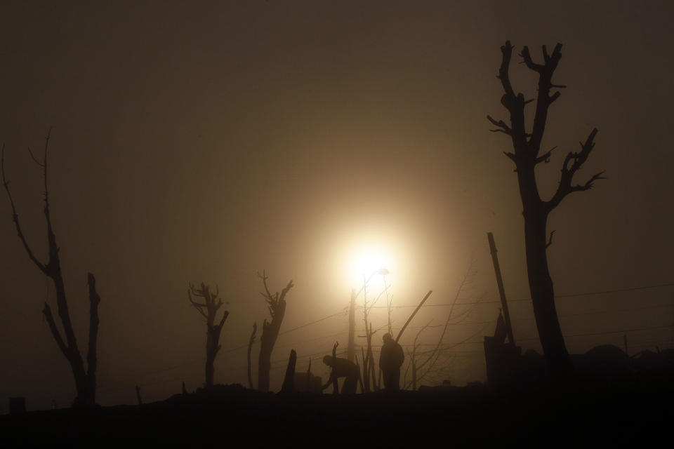 Men clear debris from destroyed homes after wildfire burned through urban areas of the city of Valparaiso,Tuesday Apr. 15, 2014. A raging fire leaped from hilltop to hilltop in this port city, killing dozens of people and destroying thousands of homes. (AP Photo/Luis Hidalgo).