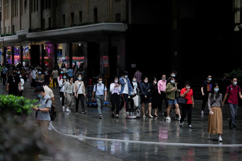 People wearing protective face masks walk on a street, following the coronavirus disease (COVID-19) outbreak, in Shanghai