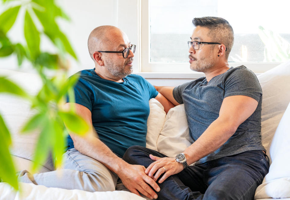 A couple at home talking openly as they sit together on the sofa.