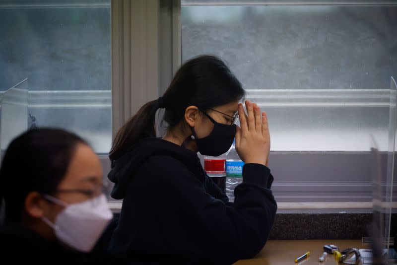 A student prays ahead of the annual college entrance examinations amid the coronavirus disease (COVID-19) pandemic at an exam hall in Seoul