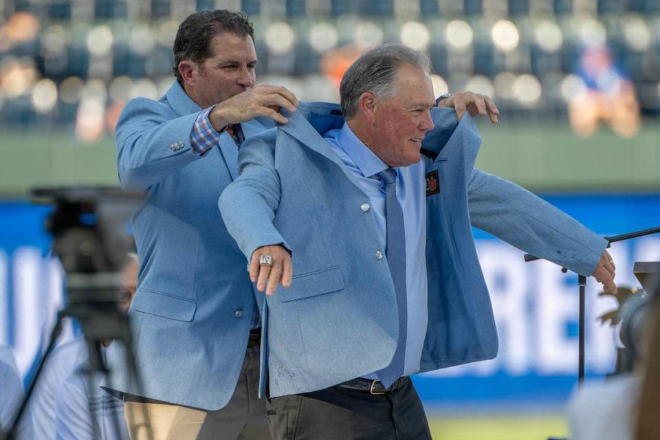 Former Kansas City Royals manager Ned Yost receives his Hall of Fame coat from former first baseman Michael Sweeney during his induction ceremony into the Kansas City Royals Hall of Fame at Kauffman Stadium on Saturday, Sept. 2, 2023, in Kansas City. Emily Curiel/ecuriel@kcstar.com