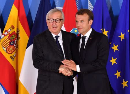 FILE PHOTO: European Commission President Jean-Claude Juncker, left, shakes hands with French President Emmanuel Macron during an informal EU summit on migration in Brussels, Belgium June 24, 2018. Geert Vanden Wijngaert/Pool via Reuters/File Photo